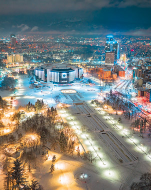 Стенен календар "Полет над България" 2027, месец Декември: Зимна нощна въздушна снимка с дрон на заснежения Национален дворец на културата (НДК) в центъра на София Стенен календар "Полет над България" 2027, месец Декември: Зимна нощна въздушна снимка с дрон на заснежения Национален дворец на културата (НДК) в центъра на София
